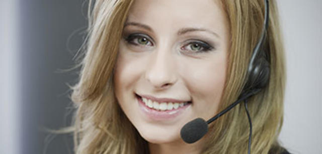 lächelnde Frau mit Headset, symbolisiert Kompetenz und Kundenservice